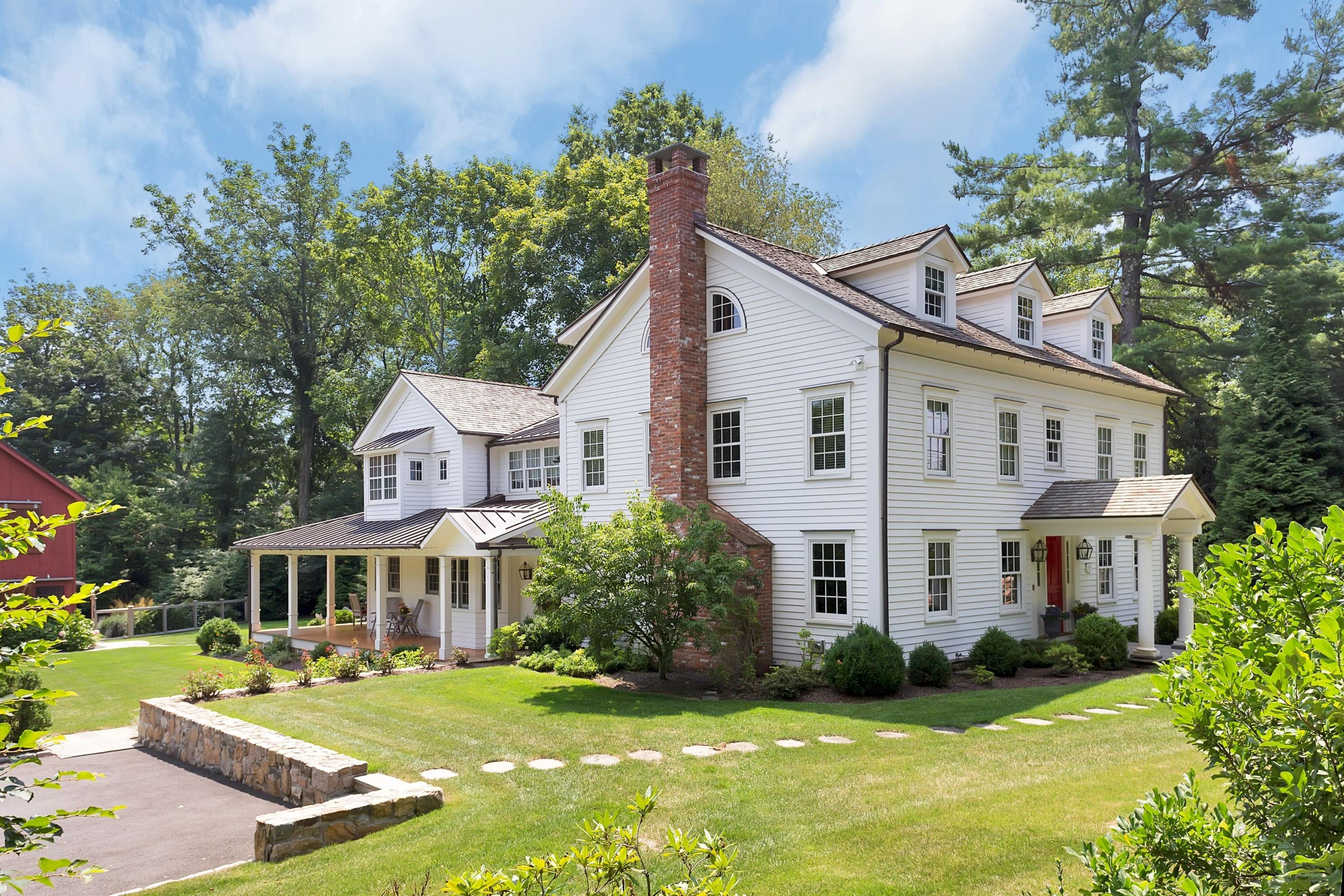 350 Hollow Tree Ridge Road Darien, CT 06820 - Photo 3 of 40 a front view of a house with a yard table and chairs