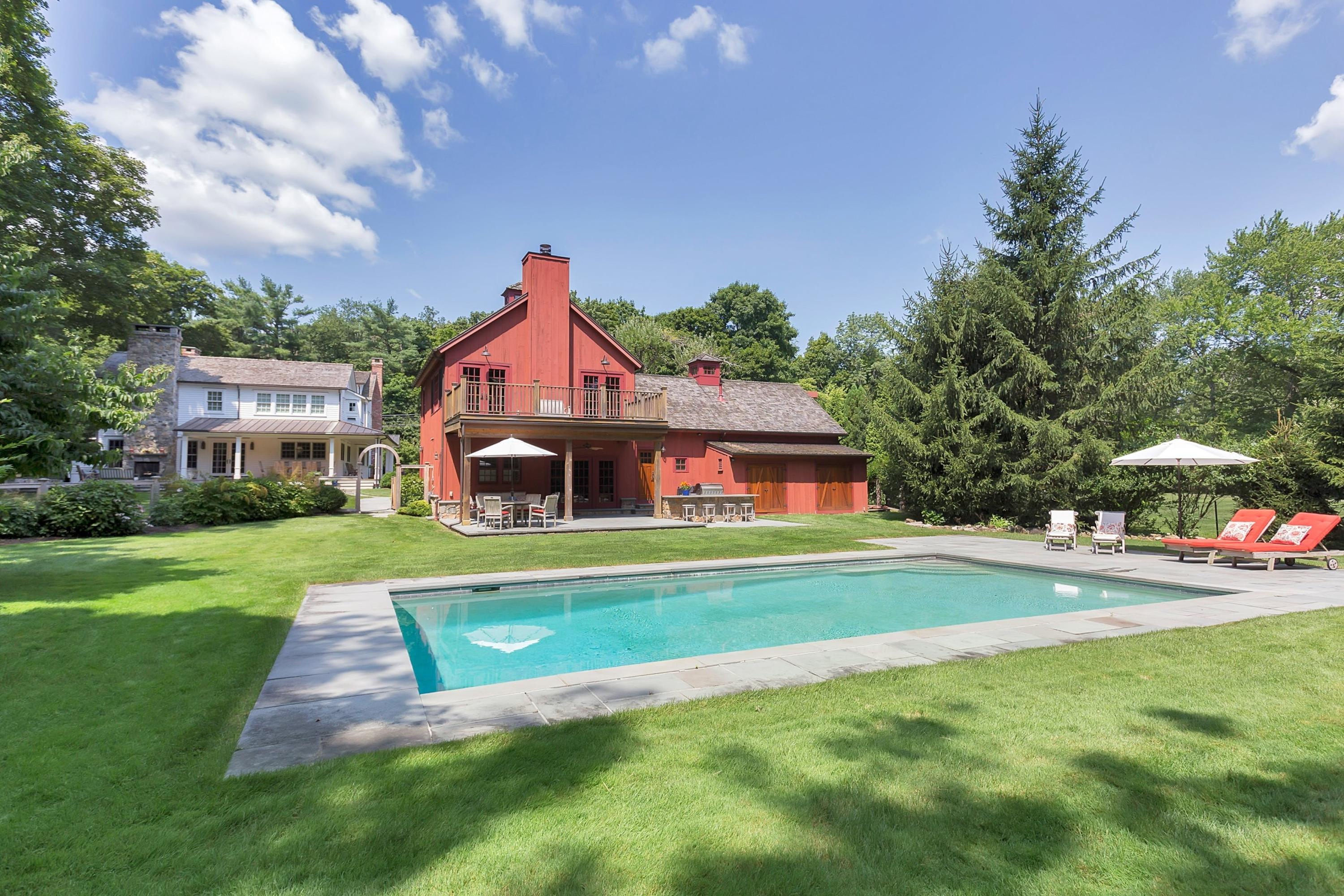 350 Hollow Tree Ridge Road Darien, CT 06820 - Photo 33 of 40 a front view of a house with a yard table and chairs