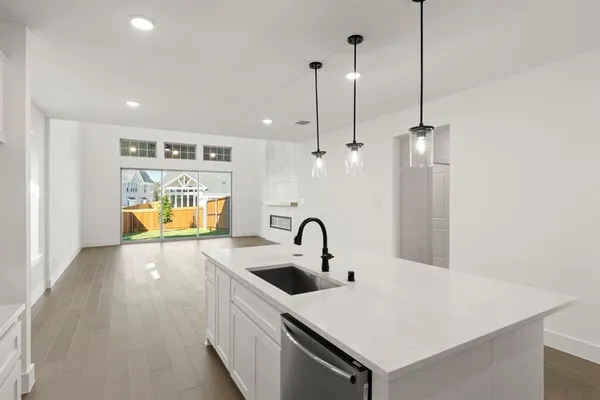 a kitchen with a sink a counter space and a view of living room