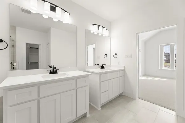 a bathroom with a double vanity sink mirror and bathtub