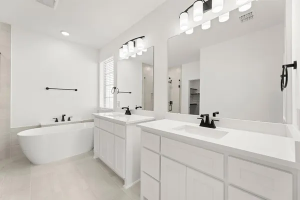 a spacious bathroom with a double vanity sink mirror and bathtub