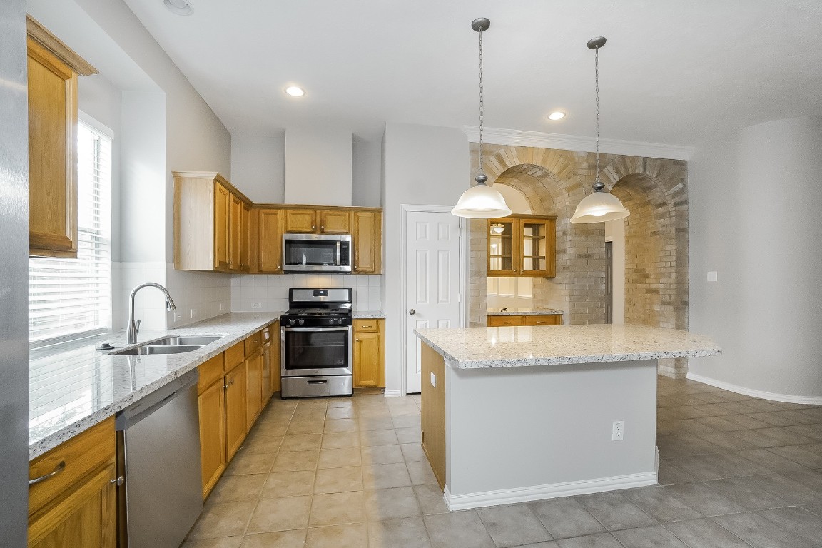 16042 Belleshire Lane Houston, TX 77084 - Photo 7 of 18 a large kitchen with stainless steel appliances granite countertop a stove a sink and a granite counter top