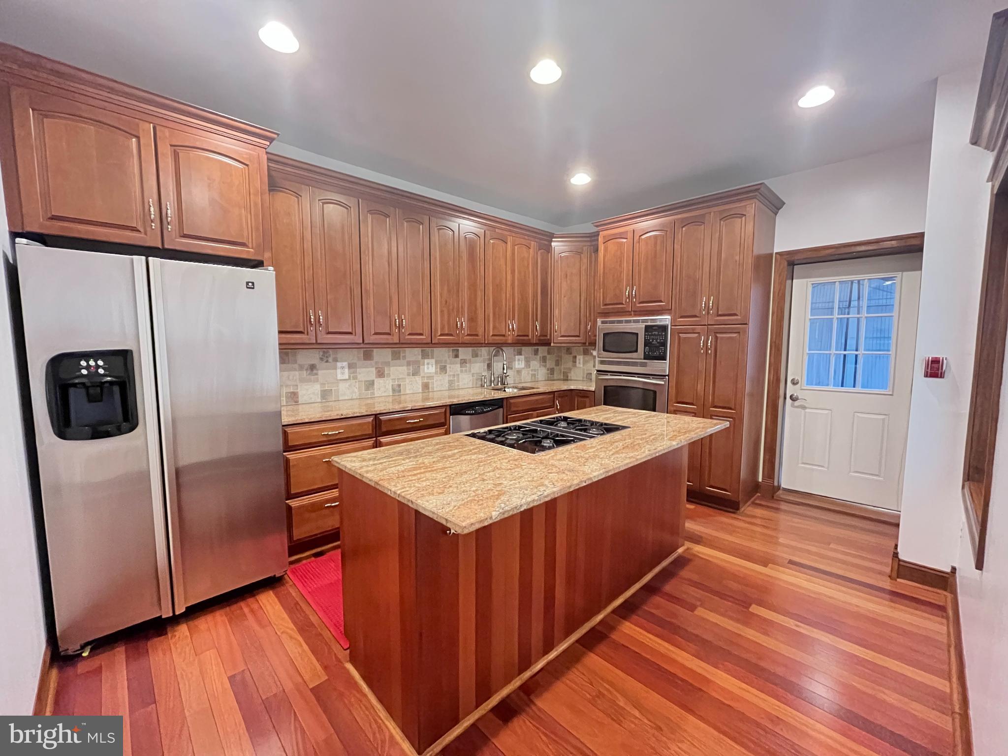 a kitchen with kitchen island stainless steel appliances a stove a sink and a refrigerator