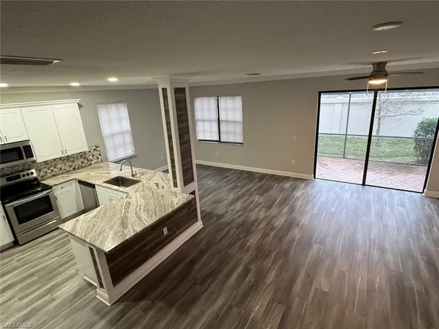 a kitchen with stainless steel appliances granite countertop a stove a refrigerator and a microwave