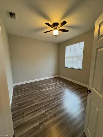 a living room with stainless steel appliances granite countertop furniture wooden floor and a rug
