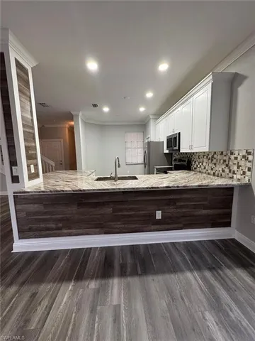 a view of kitchen with refrigerator stove and wooden floor