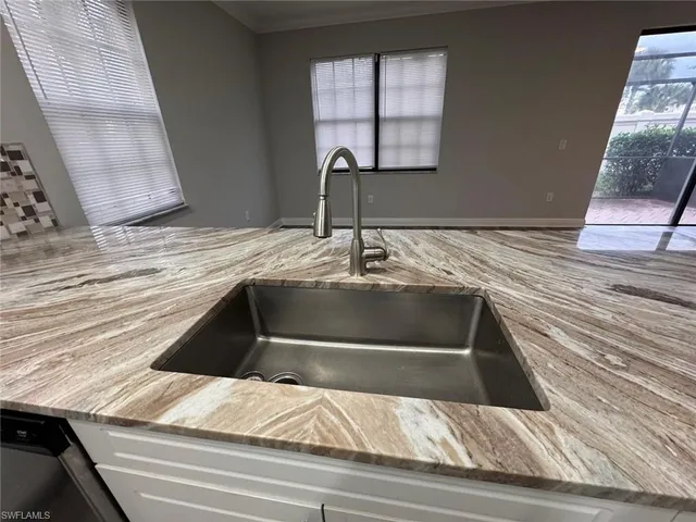 a view of living room with granite countertop cabinets and flat screen tv