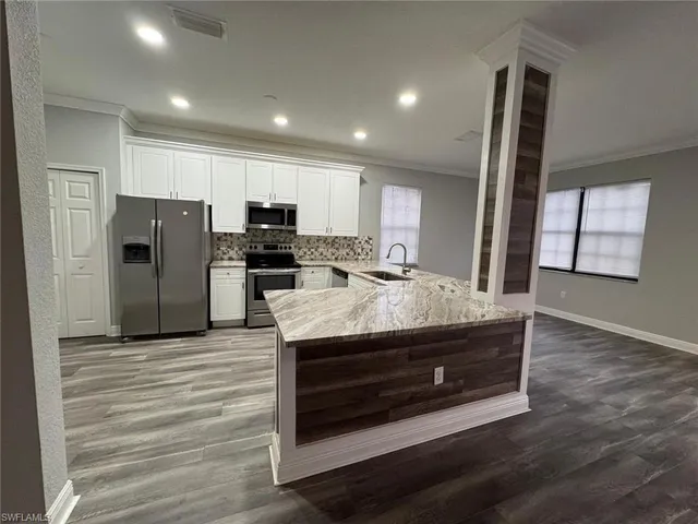 a view of living room with granite countertop cabinets and flat screen tv