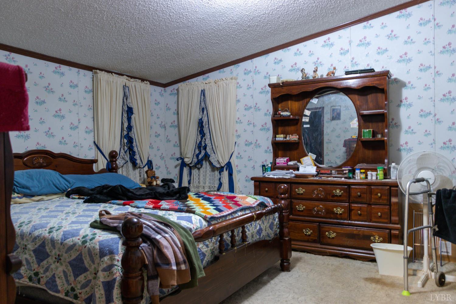 3160 Owens Mill Road Gretna, VA 24557 - Photo 18 of 59 a bedroom with a bed a dresser and potted plants on the dresser