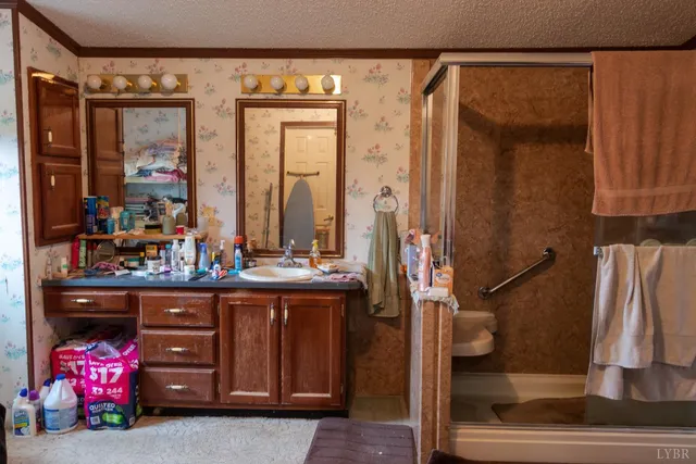 a bathroom with a sink a toilet and shower