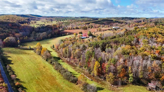 a view of a house with a wooden deck and a tree