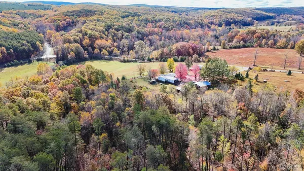 an aerial view of a house with a yard and wooden fence