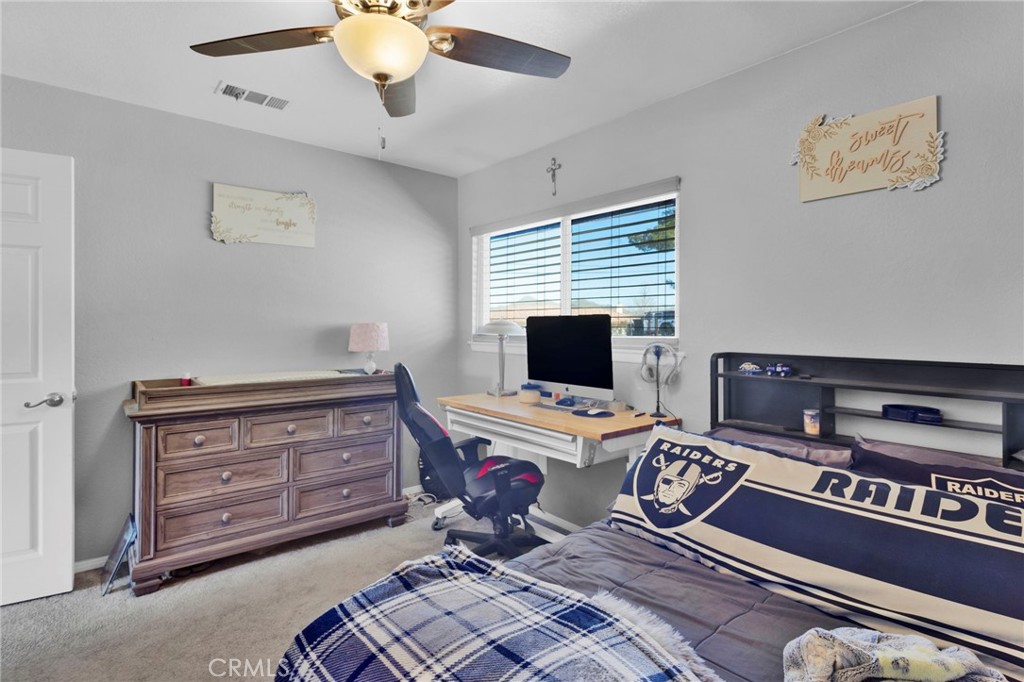 18608 Cocqui Road Apple Valley, CA 92307 - Photo 14 of 30 a bedroom with a bed and a chandelier