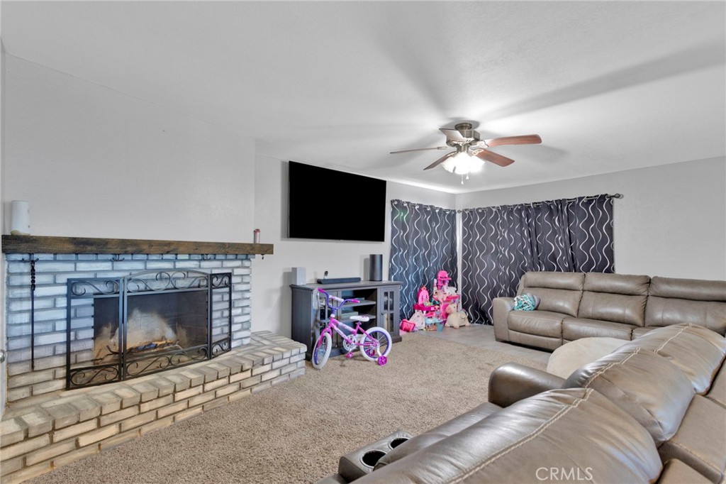 18608 Cocqui Road Apple Valley, CA 92307 - Photo 8 of 30 a living room with furniture a flat screen tv and a fireplace