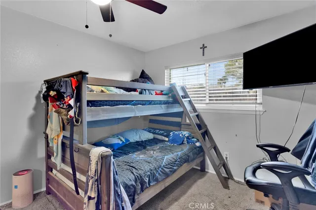 a bedroom with furniture and a flat screen tv