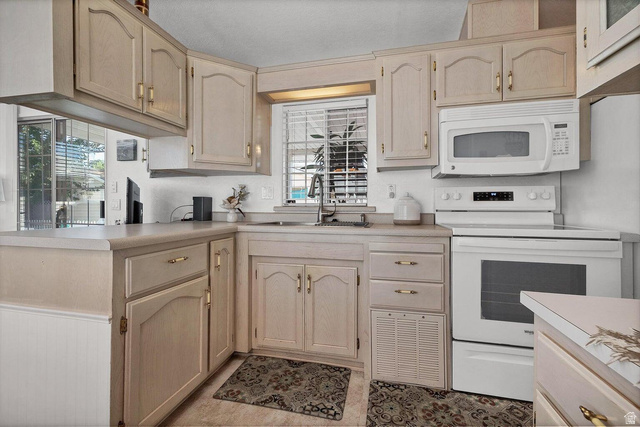 2990 East Riverside Drive, Unit 173 St. George, UT 84790 - Photo 8 of 38 Kitchen featuring neutral cabinetry, a white appliance suite, light countertops, and a window with blinds