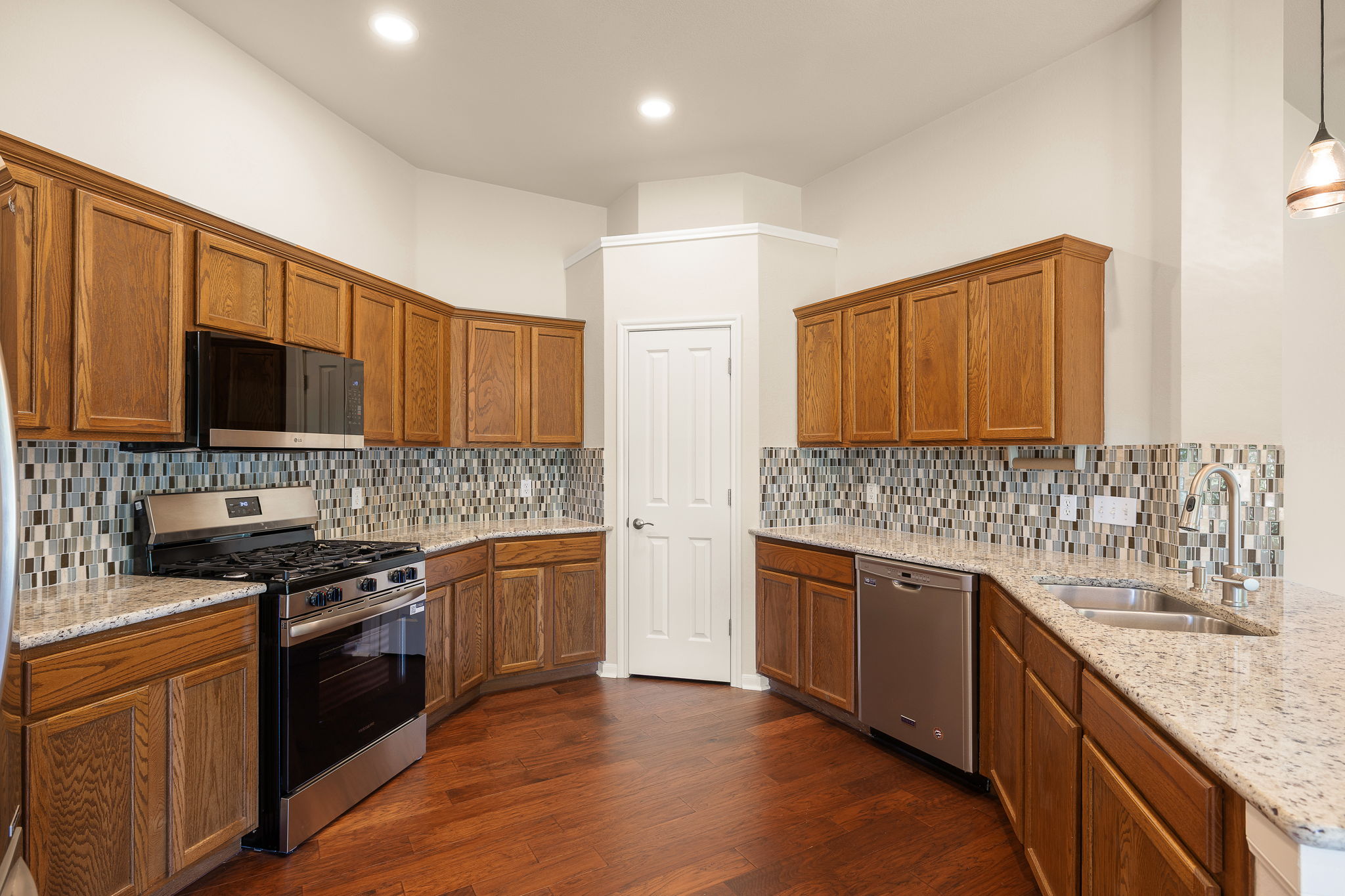 1100 Springbrook Road Pflugerville, TX 78660 - Photo 12 of 23 A well-appointed kitchen features stainless steel appliances, gleaming hardwood flooring, and abundant cabinetry.
