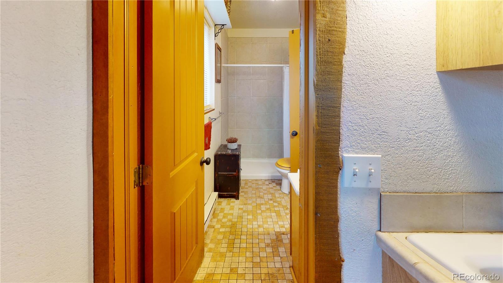 1011 Castle Ridge View Cripple Creek, CO 80813 - Photo 23 of 40 a bathroom with a bathtub and a shower