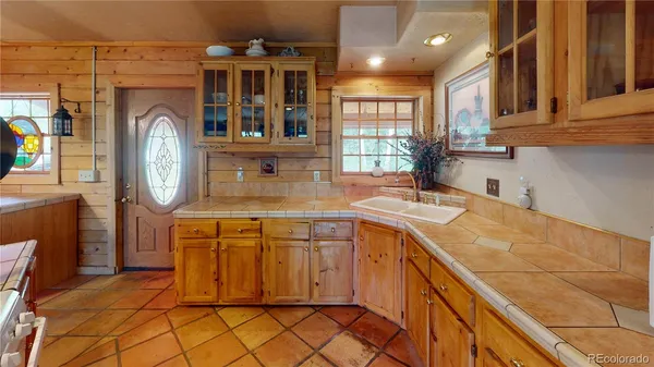 a kitchen with a sink a clock and cabinets