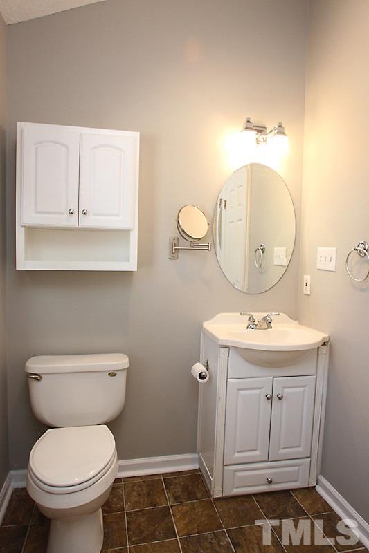 3449 Mill Run, Unit 3449 Raleigh, NC 27612 - Photo 8 of 12 a bathroom with a sink a toilet and mirror