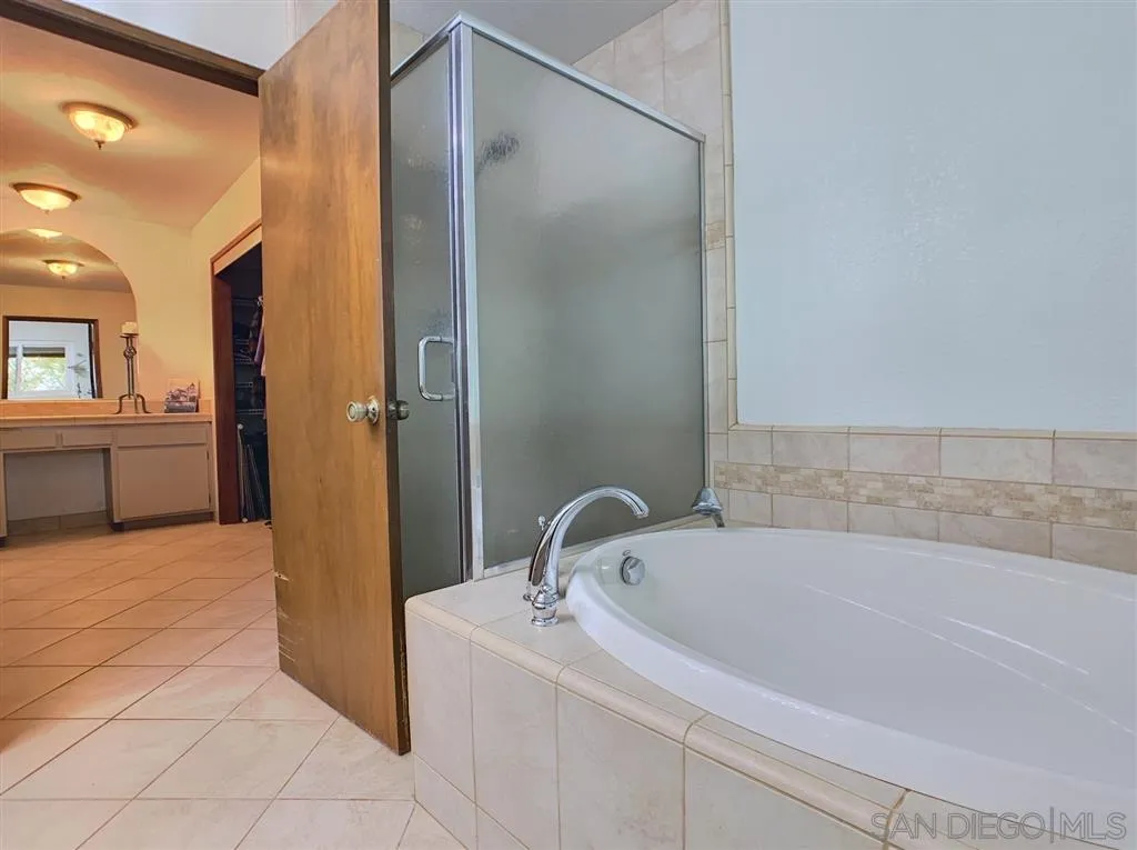 21152 Sutherland Dam Road Ramona, CA 92065 - Photo 13 of 25 a white bath tub sitting in a bathroom and mirror