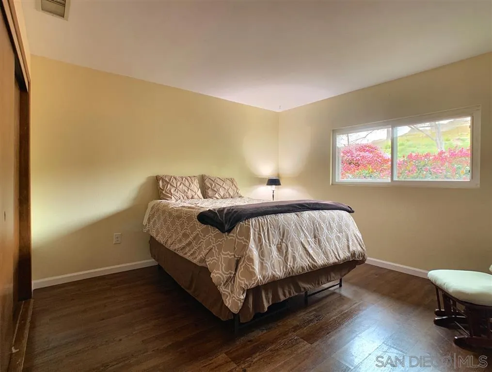 21152 Sutherland Dam Road Ramona, CA 92065 - Photo 15 of 25 a bedroom with a bed and wooden floor