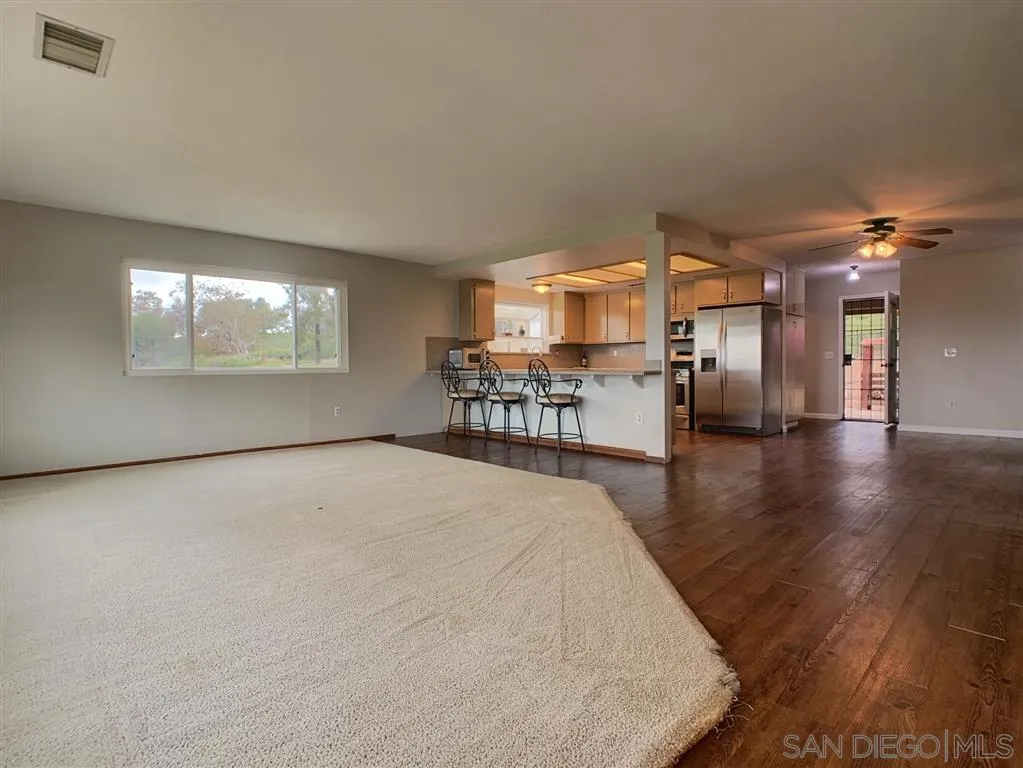 21152 Sutherland Dam Road Ramona, CA 92065 - Photo 6 of 25 a large bed sitting in a room and kitchen view