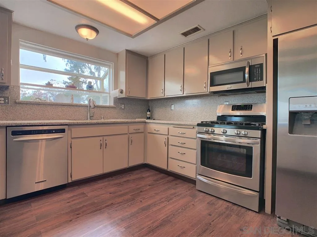 21152 Sutherland Dam Road Ramona, CA 92065 - Photo 8 of 25 a kitchen with granite countertop white cabinets and stainless steel appliances