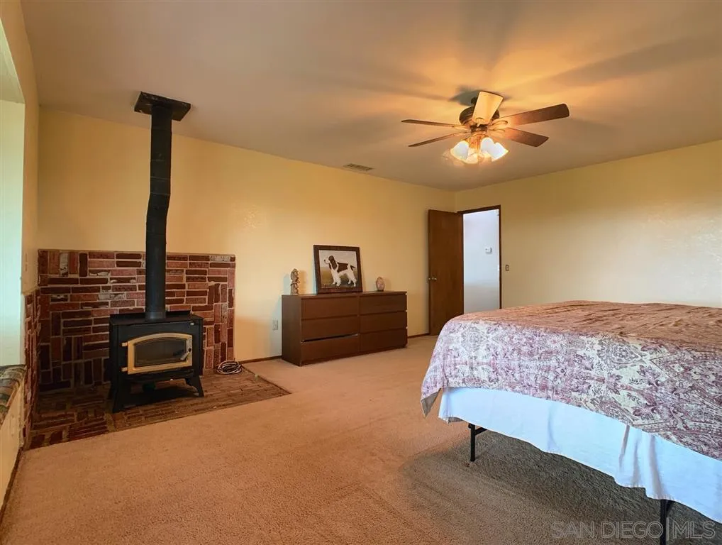 21152 Sutherland Dam Road Ramona, CA 92065 - Photo 10 of 25 a bedroom with a bed and a chandelier