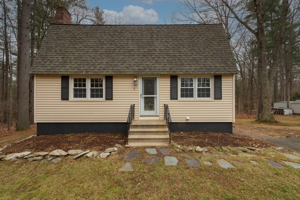 a view of a house with backyard and trees