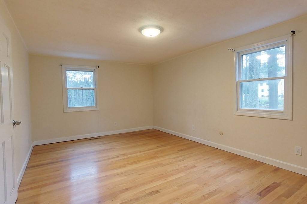 5 Peach Lane Townsend, MA 01469 - Photo 17 of 32 a view of an empty room with wooden floor and a window