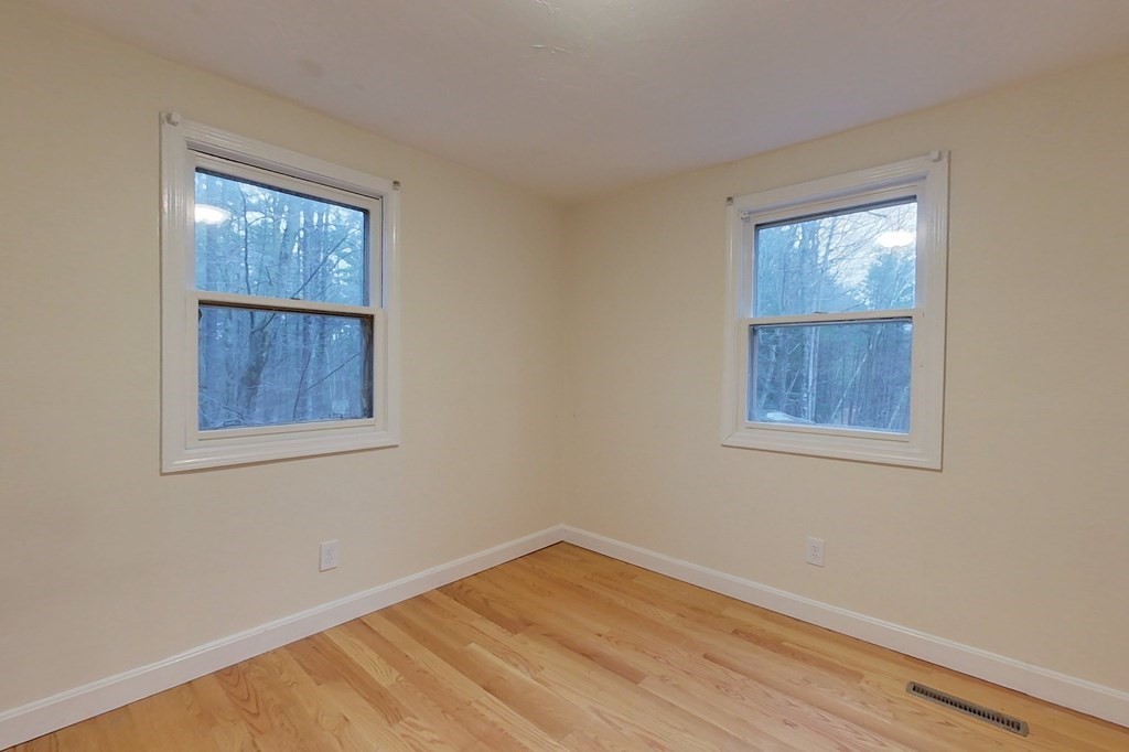 5 Peach Lane Townsend, MA 01469 - Photo 20 of 32 a view of an empty room with a window and wooden floor
