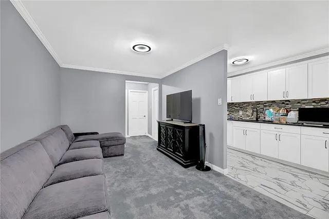 a living room with furniture a flat screen tv and white walls