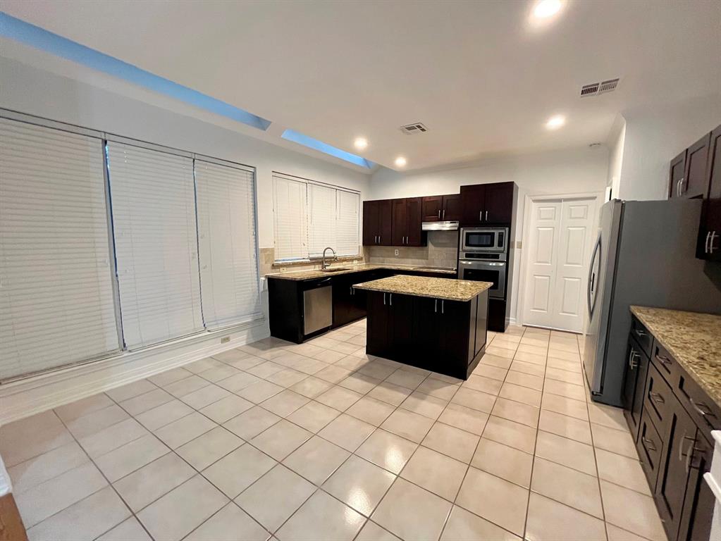 1840 Wind Hill Road Rockwall, TX 75087 - Photo 13 of 28 a kitchen with stainless steel appliances granite countertop a refrigerator sink and cabinets