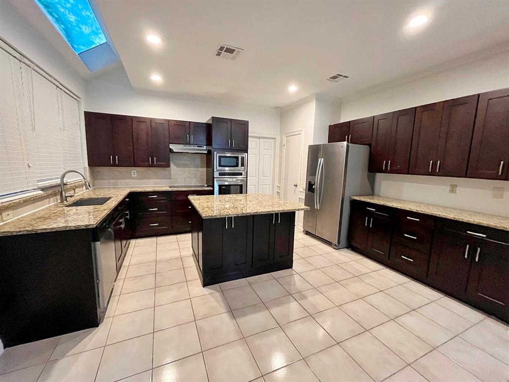 1840 Wind Hill Road Rockwall, TX 75087 - Photo 14 of 28 a kitchen with stainless steel appliances a sink a stove a refrigerator and a refrigerator