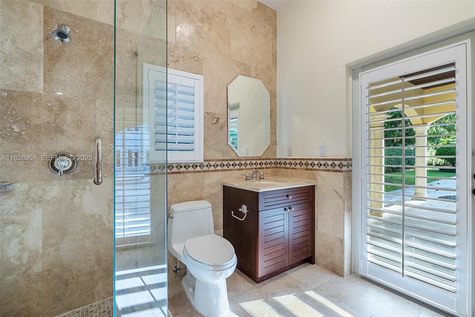 10851 Southwest 63rd Avenue Pinecrest, FL 33156 - Photo 41 of 63 a bathroom with a toilet a sink and mirror