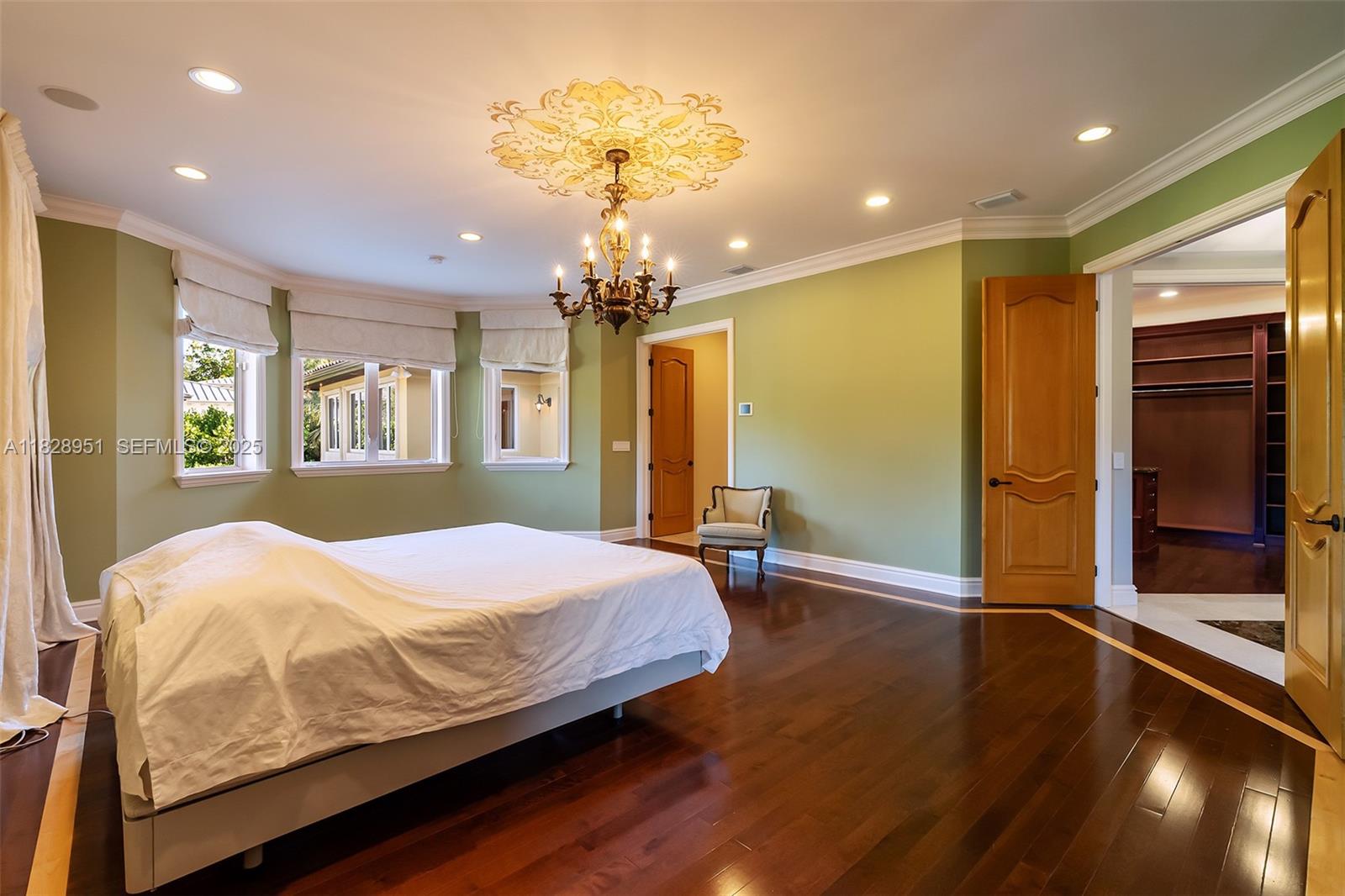 10851 Southwest 63rd Avenue Pinecrest, FL 33156 - Photo 44 of 63 a bedroom with a bed and a chandelier