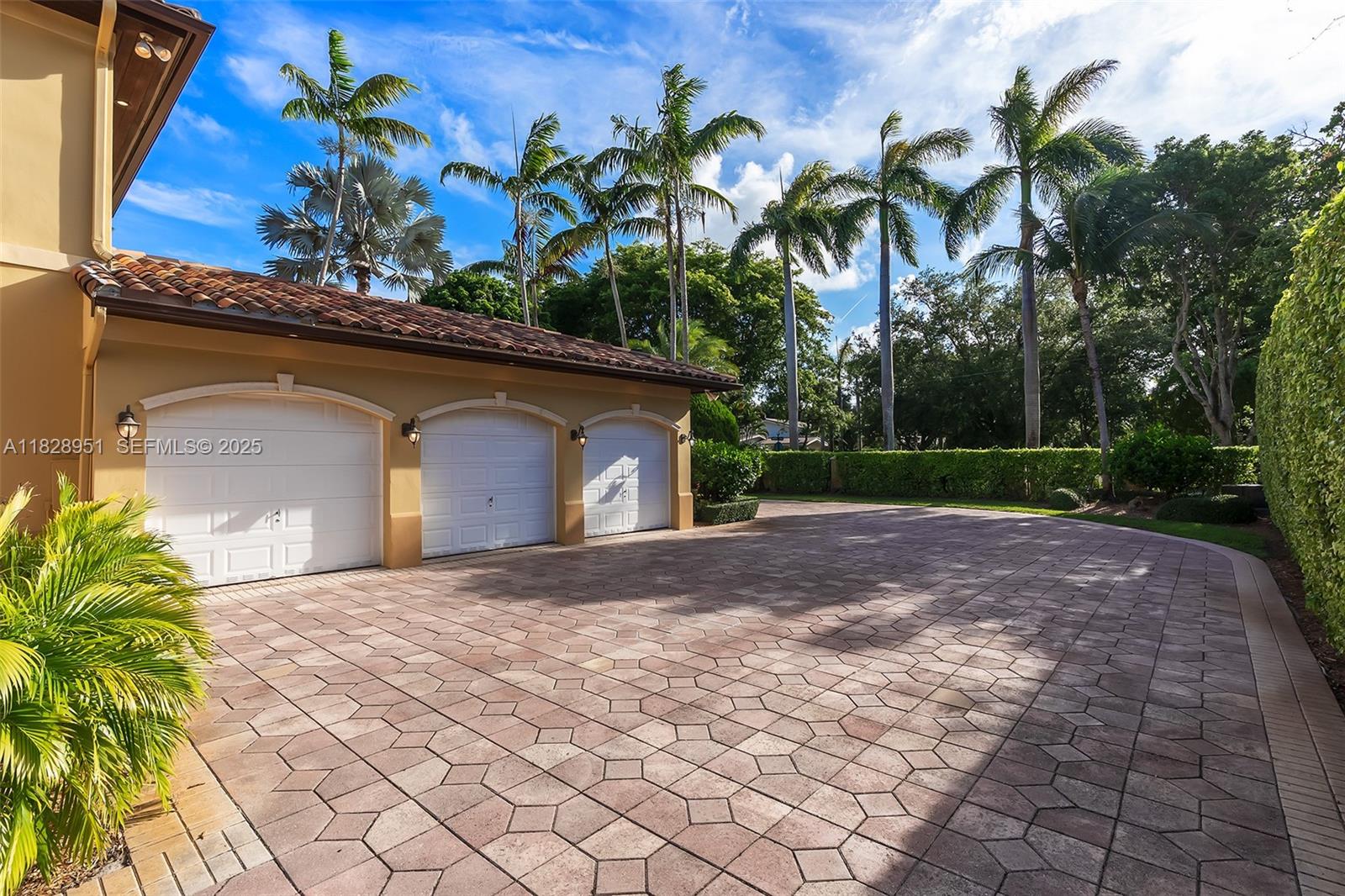 10851 Southwest 63rd Avenue Pinecrest, FL 33156 - Photo 59 of 63 a front view of a house with a yard and a garage