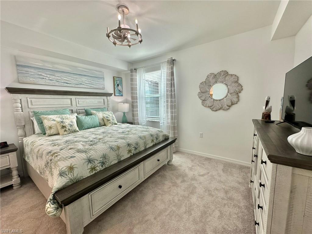 43989 Boardwalk Loop, Unit 2028 Babcock Ranch, FL 33982 - Photo 11 of 47 a bed sitting in a bedroom next to a window and a chair