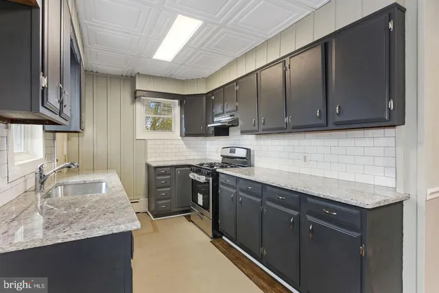 a kitchen with stainless steel appliances granite countertop wooden cabinets a stove top oven a sink and dishwasher