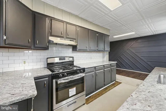 a kitchen with granite countertop wooden cabinets and stainless steel appliances