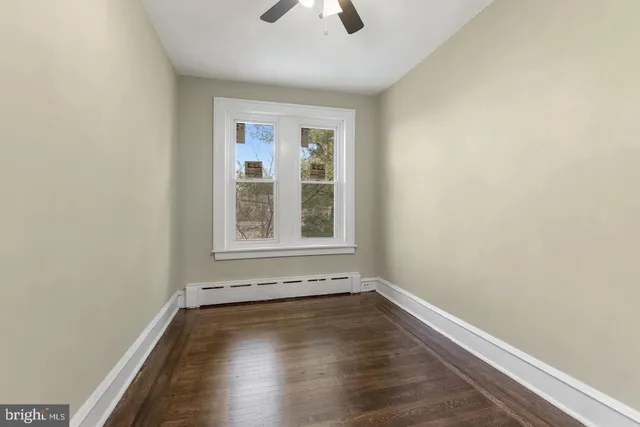 an empty room with a window and wooden floor