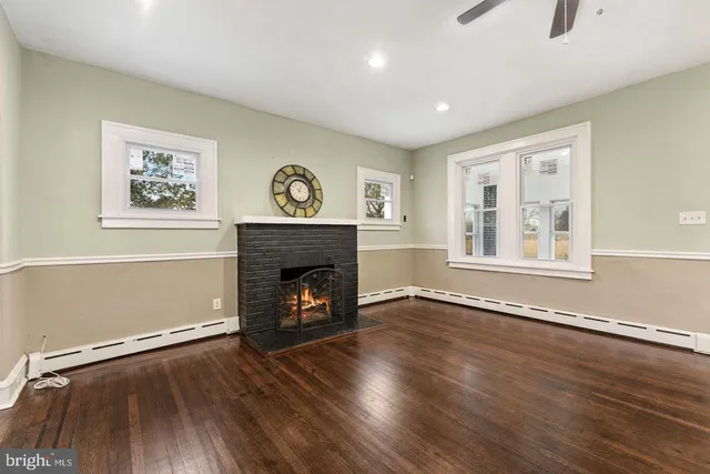 an empty room with windows and fireplace