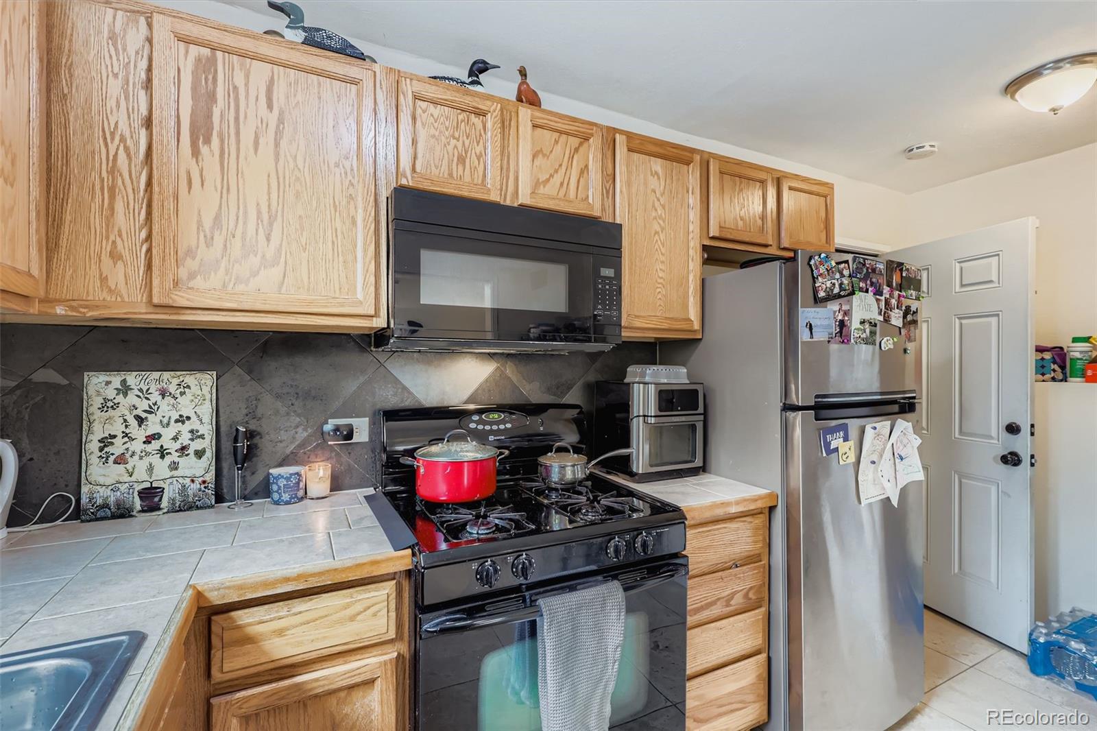 452 Perry Street Denver, CO 80204 - Photo 14 of 29 a kitchen with stainless steel appliances granite countertop a refrigerator stove and sink