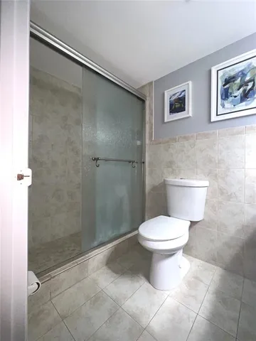 a bathroom with a toilet and a shower