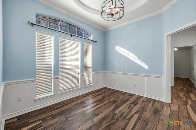 a view of a livingroom with wooden floor and a large window