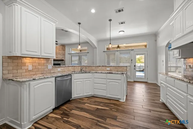 a kitchen with stainless steel appliances granite countertop a sink and cabinets