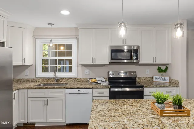 a kitchen with stainless steel appliances granite countertop a stove a sink and a microwave