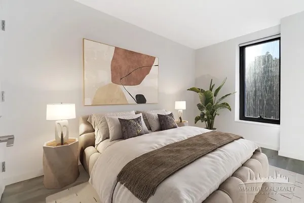 a bedroom with a large bed and a potted plant