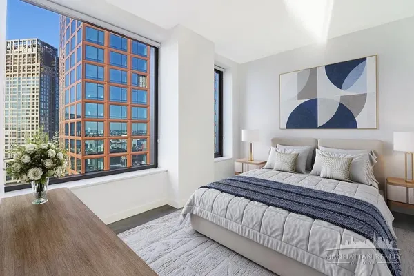 a bedroom with a bed and a potted plant next to a window